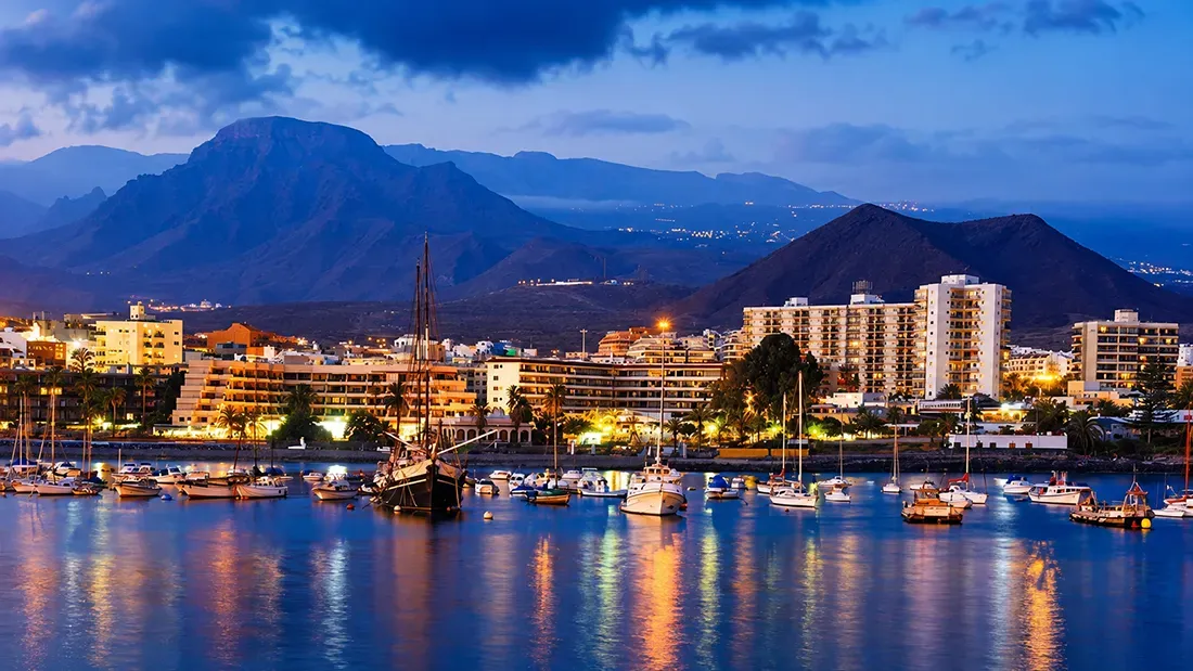 Evening harbor view with boats moored before Tenerife mountains