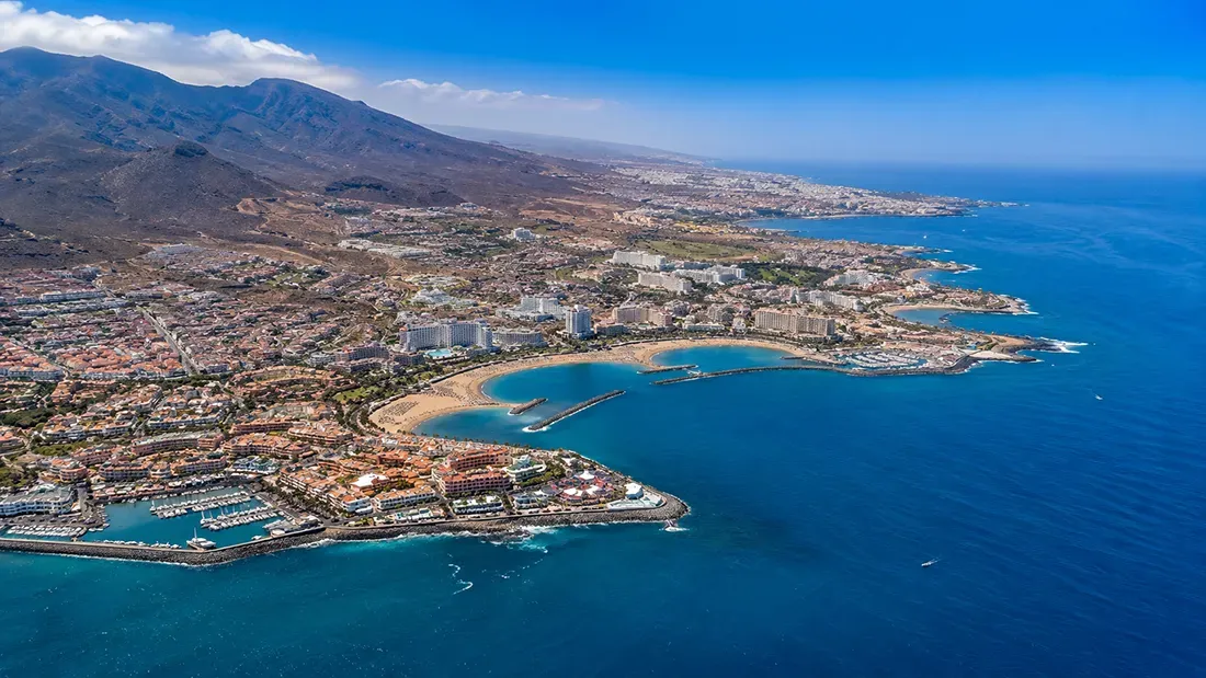 Aerial view of Tenerife coastal resort town and beaches from boat
