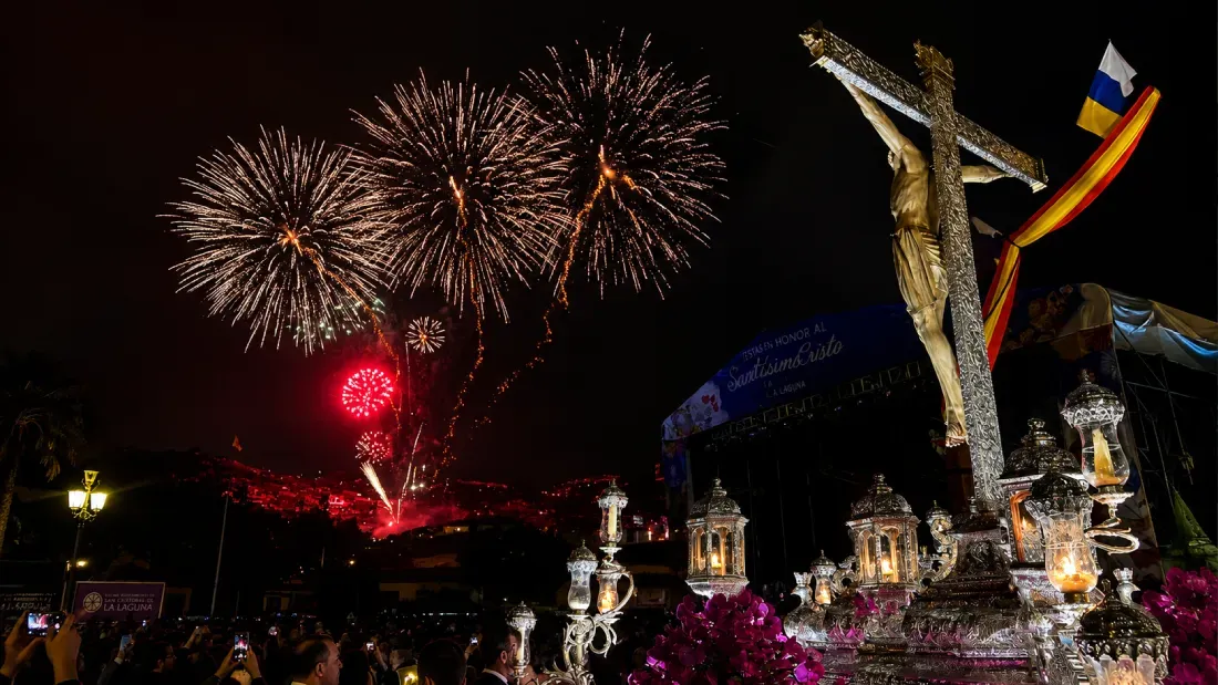 Fireworks explode over illuminated Christ statue at nighttime celebration